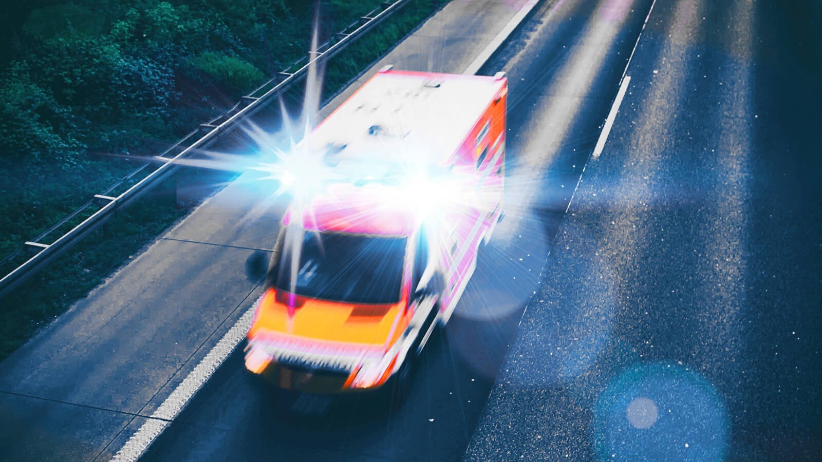 Ein Rettungswagen fährt mit Blaulicht über die Autobahn. 
