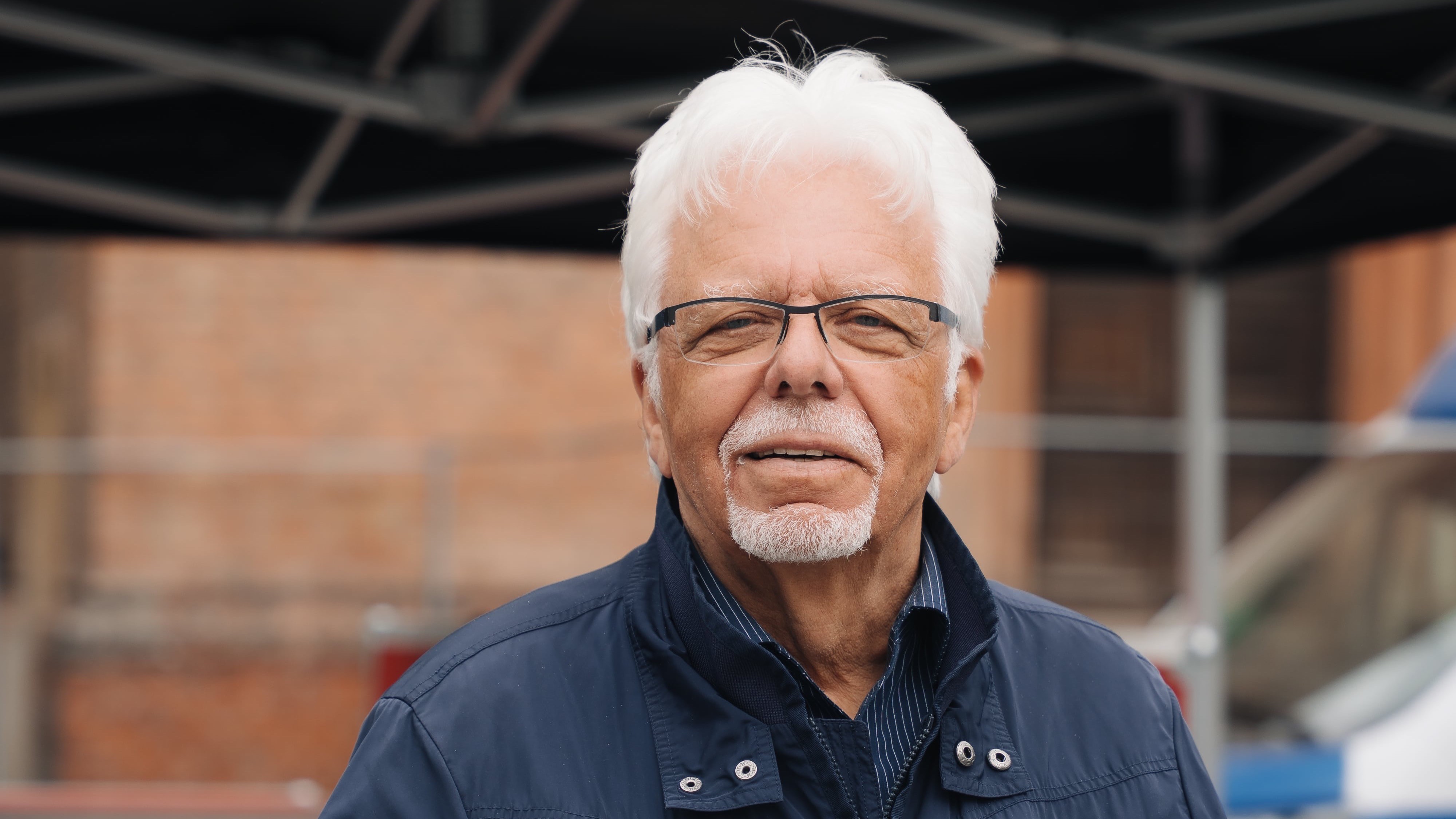 Norbert Radzanowski, Pressesprecher des BADS, steht vor einem mobilen Infostand zur Verkehrsprävention. Auf dem Tisch liegen Informationsmaterialien zu Alkohol am Steuer und sicherem Fahrverhalten.