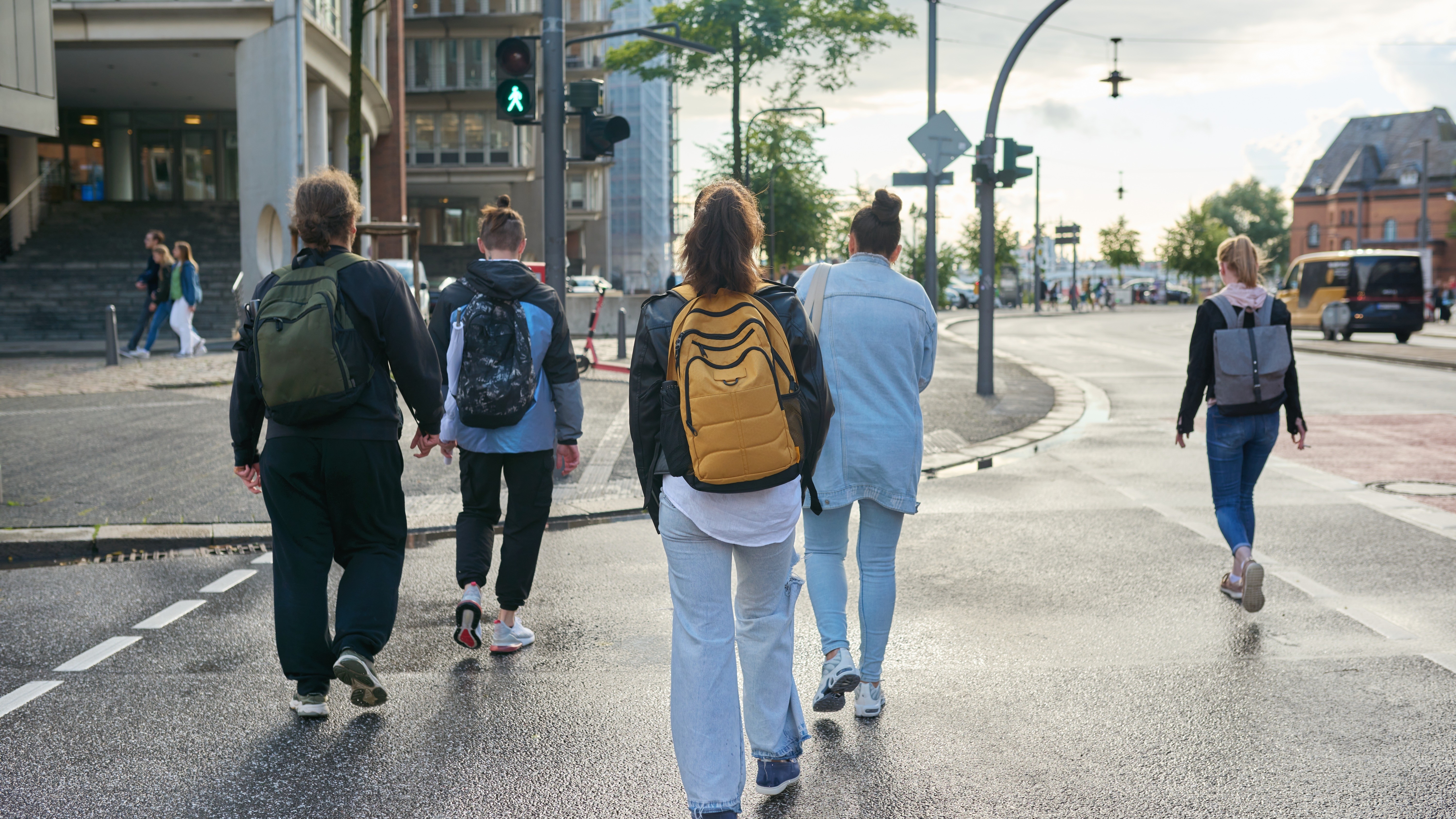 Fussgaenger_Unfallzahlen_2023 Eine Gruppe von Menschen geht über einen Fußgängerüberweg in einer Stadt.
