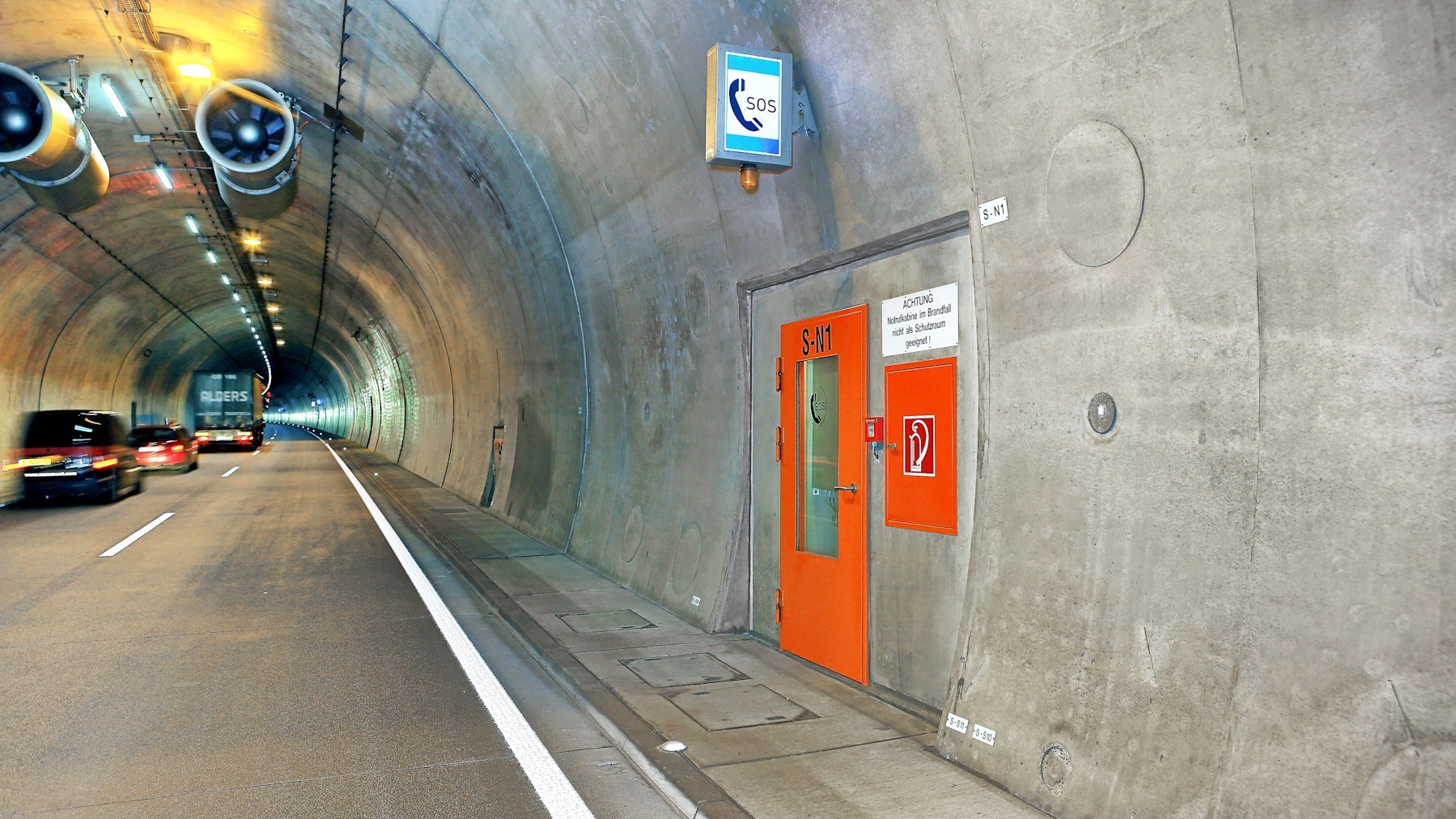 Höllbergtunnel - Tunnelquiz 16:9 Zu sehen ist ein Tunnel sowie eine Notrufstation und dahinter fahrende Autos.