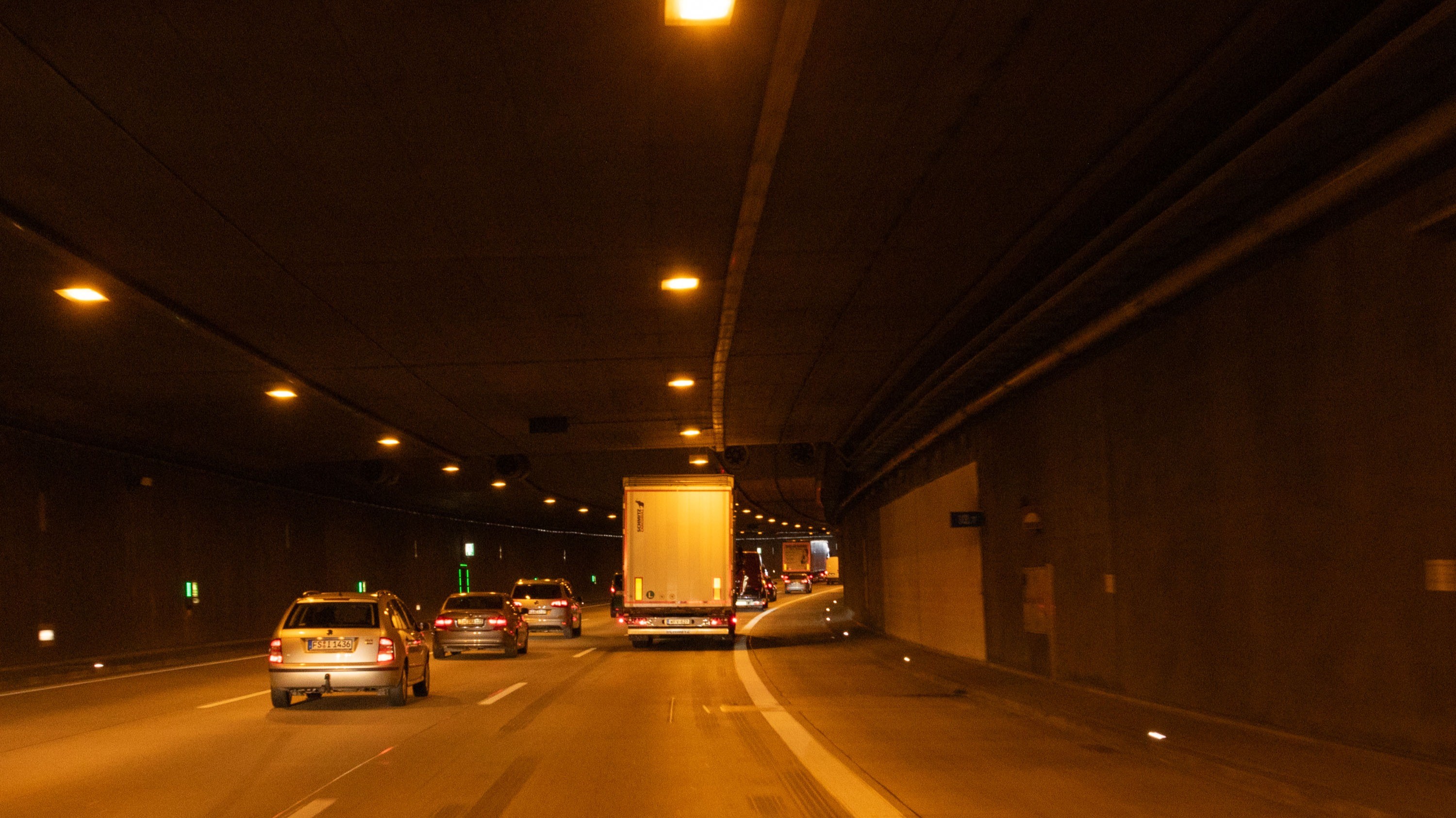 Das Foto zeigt einen Tunnel. Auf der rechten Spur fährt ein Lkw, auf der mittleren Spur fahren drei Pkw. 