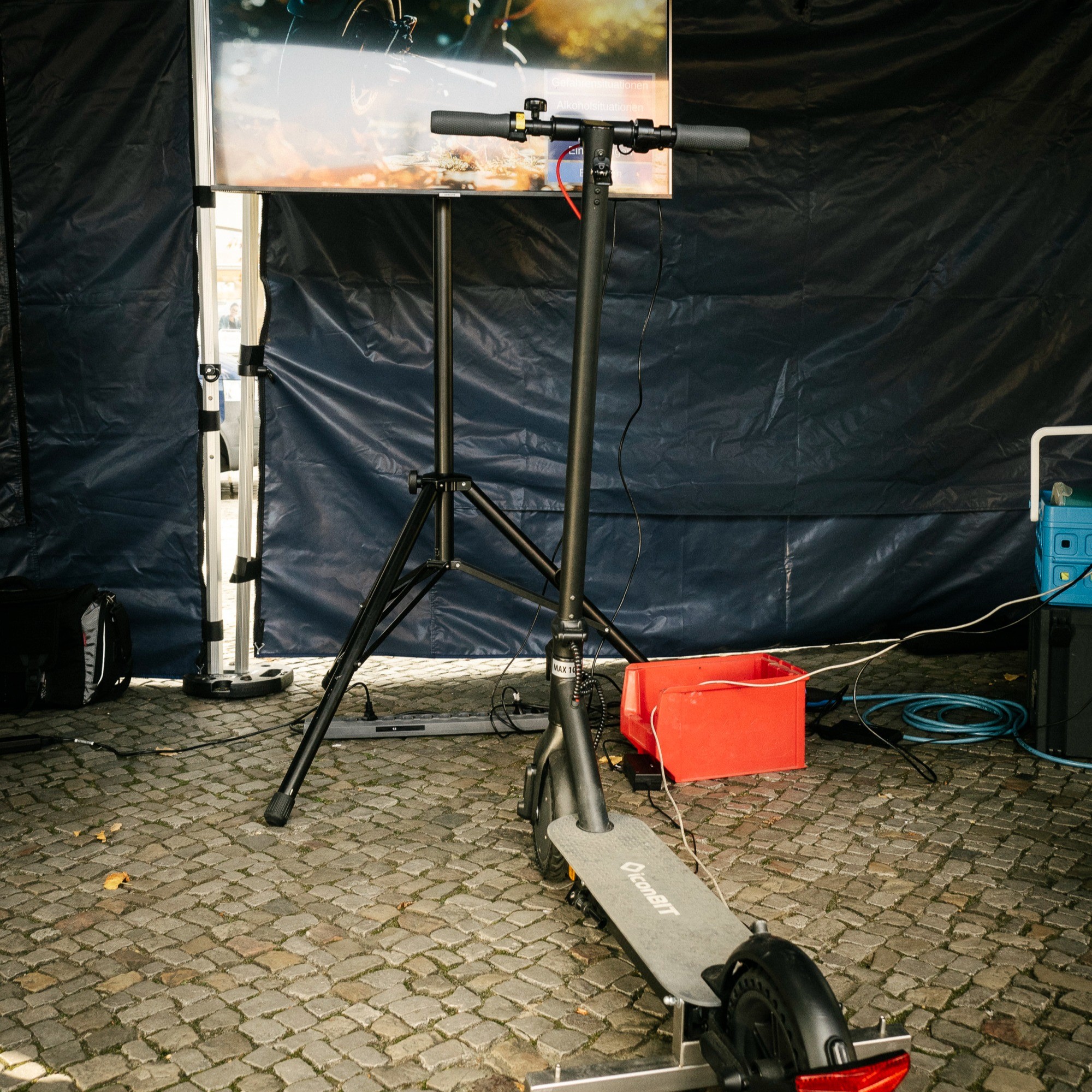 Sicher Mobil Leben Bild 2 Das Bild zeigt einen Elektroscooter, der an einen Bildschirm angeschlossen ist. Es ist der E-Scooter-Simulator der Polizei Berlin.