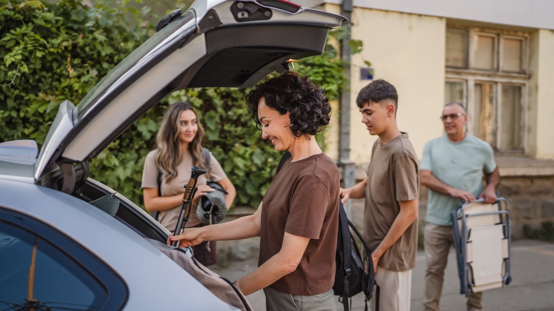 Familie Reise Kofferraum Eine Familie steht an der offenen Heckklappe eines Pkw. Sie beladen das Fahrzeug für die Urlaubsreise.