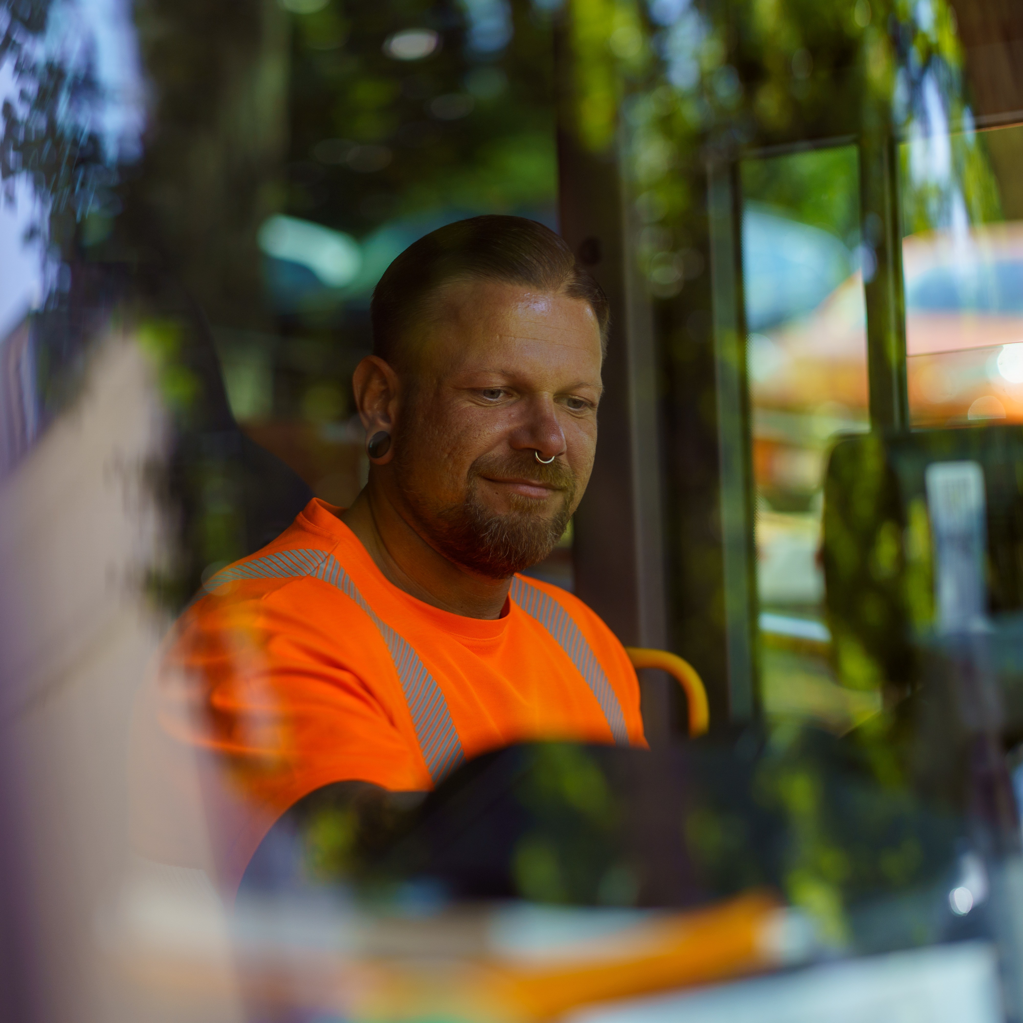 Kraftfahrer Sören Henselin sitzt im Fahrerhaus des Müllwagens. 