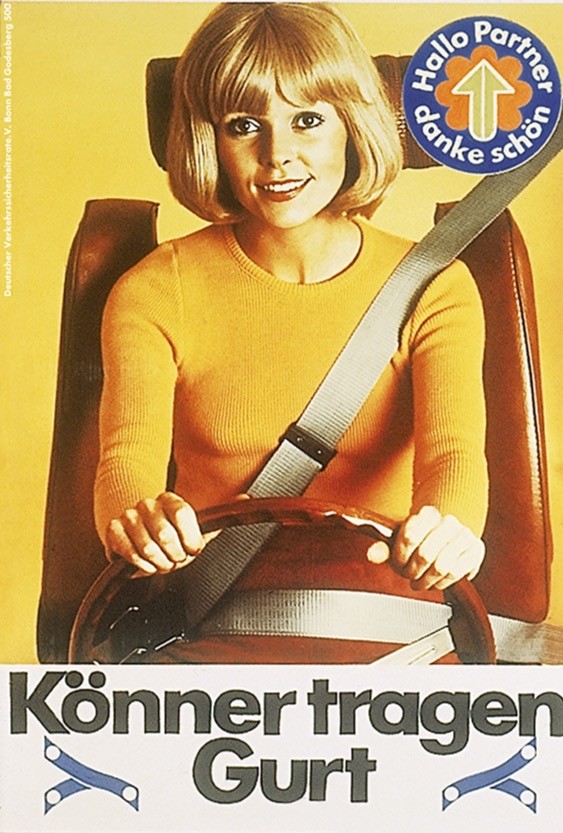 Header Ein Klick, der Leben retten kann Historisches Werbeplakat aus den Siebzigerjahren: Eine Frau sitzt angeschnallt am Steuer eines Autos und wirbt für das Tragen des Sicherheitsgurts.