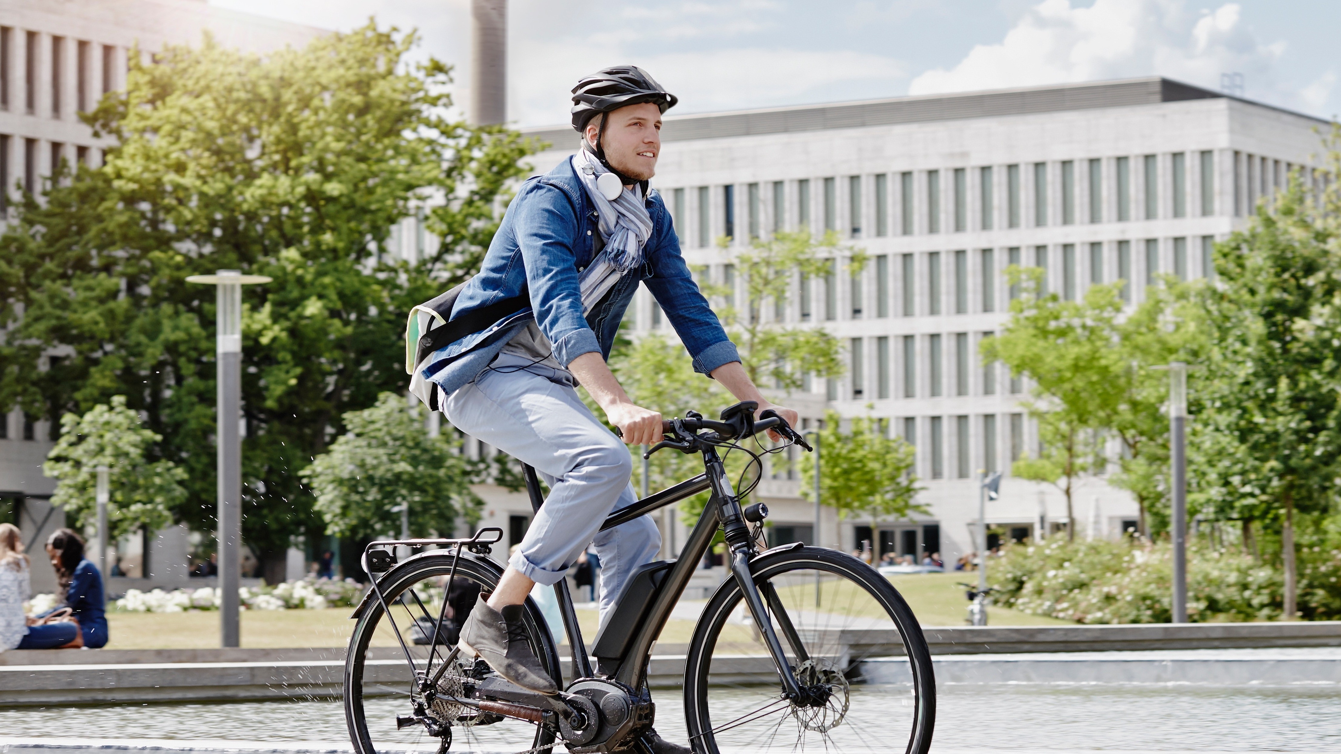 Fahrradcheck E-Bike 16:9 Eine männliche gelesene Person fährt auf einem verkehrssicheren E-Bike.