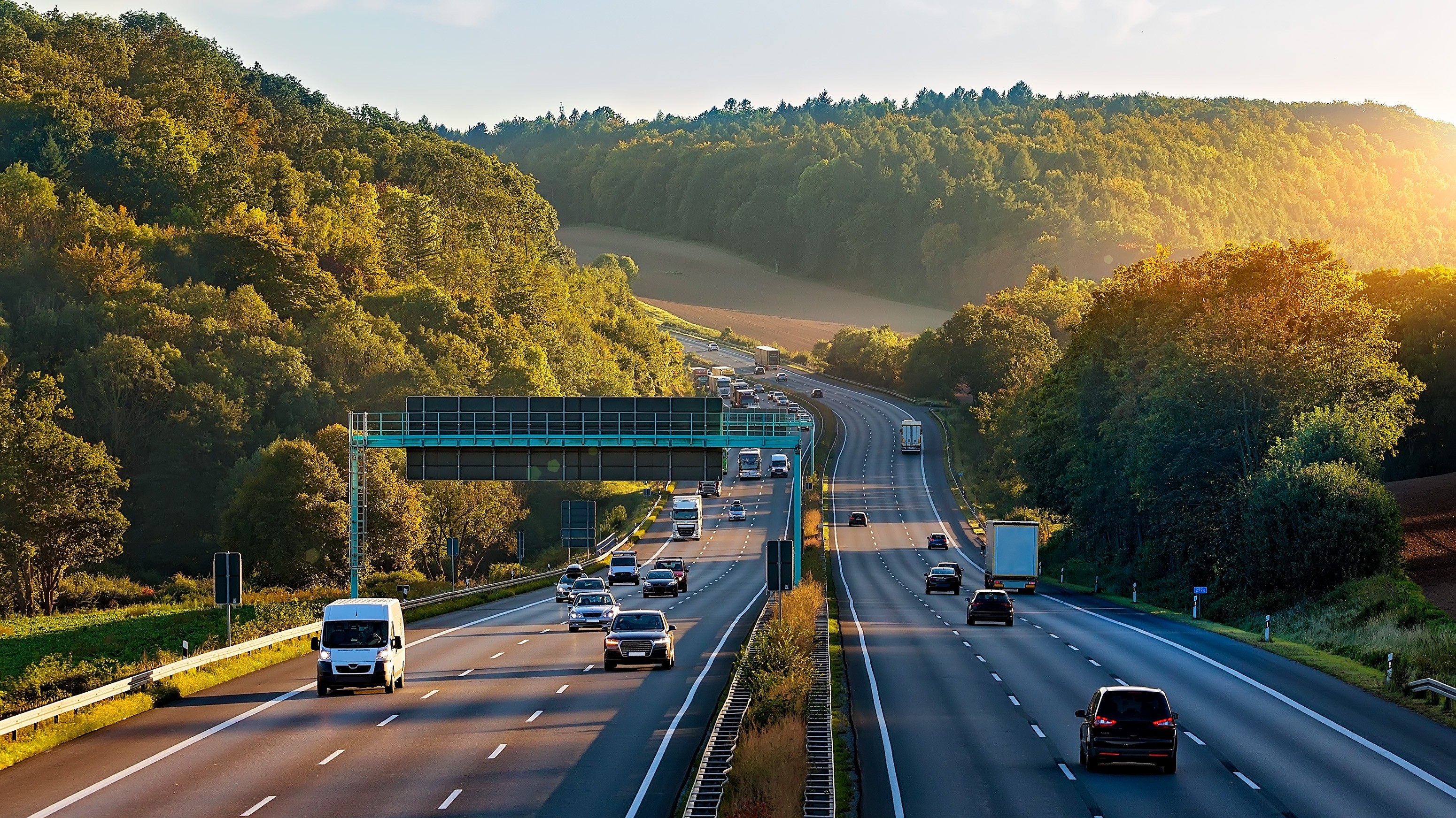 Mehrspurige Autobahn mit fließendem Verkehr bei Tageslicht.