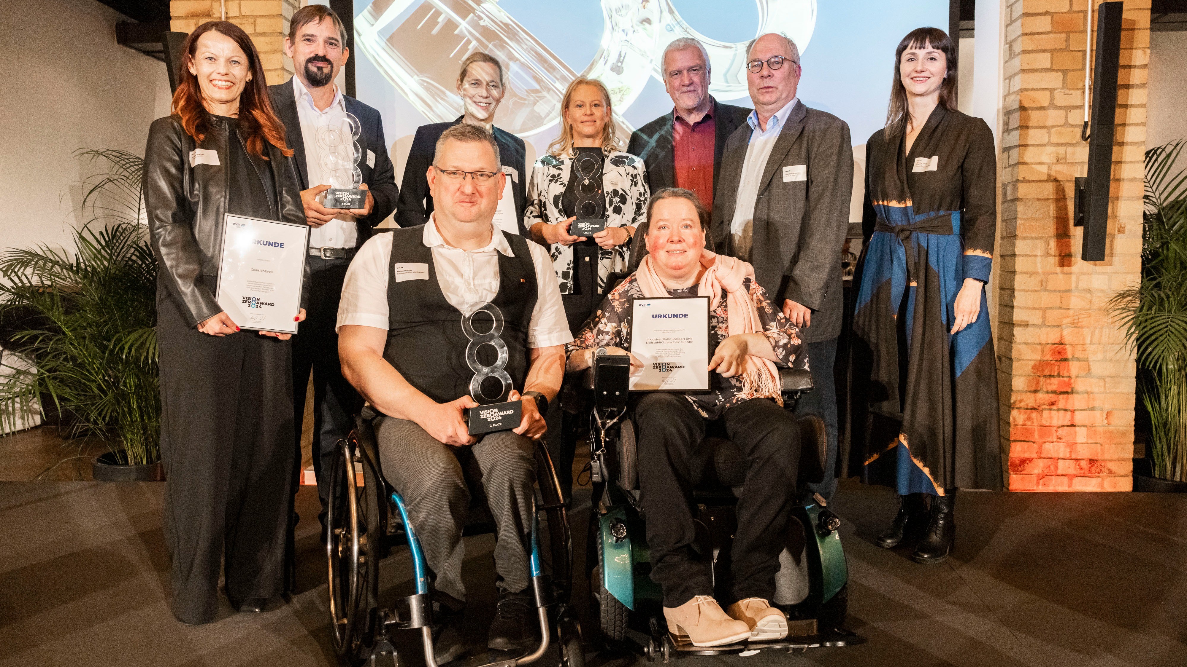 Header Vision Zero Award 2024 Gruppenbild (16:9) Auf dem Bild sind neun Personen zu sehen. Sie sind die Gewinner des Vision Zero Awards 2024