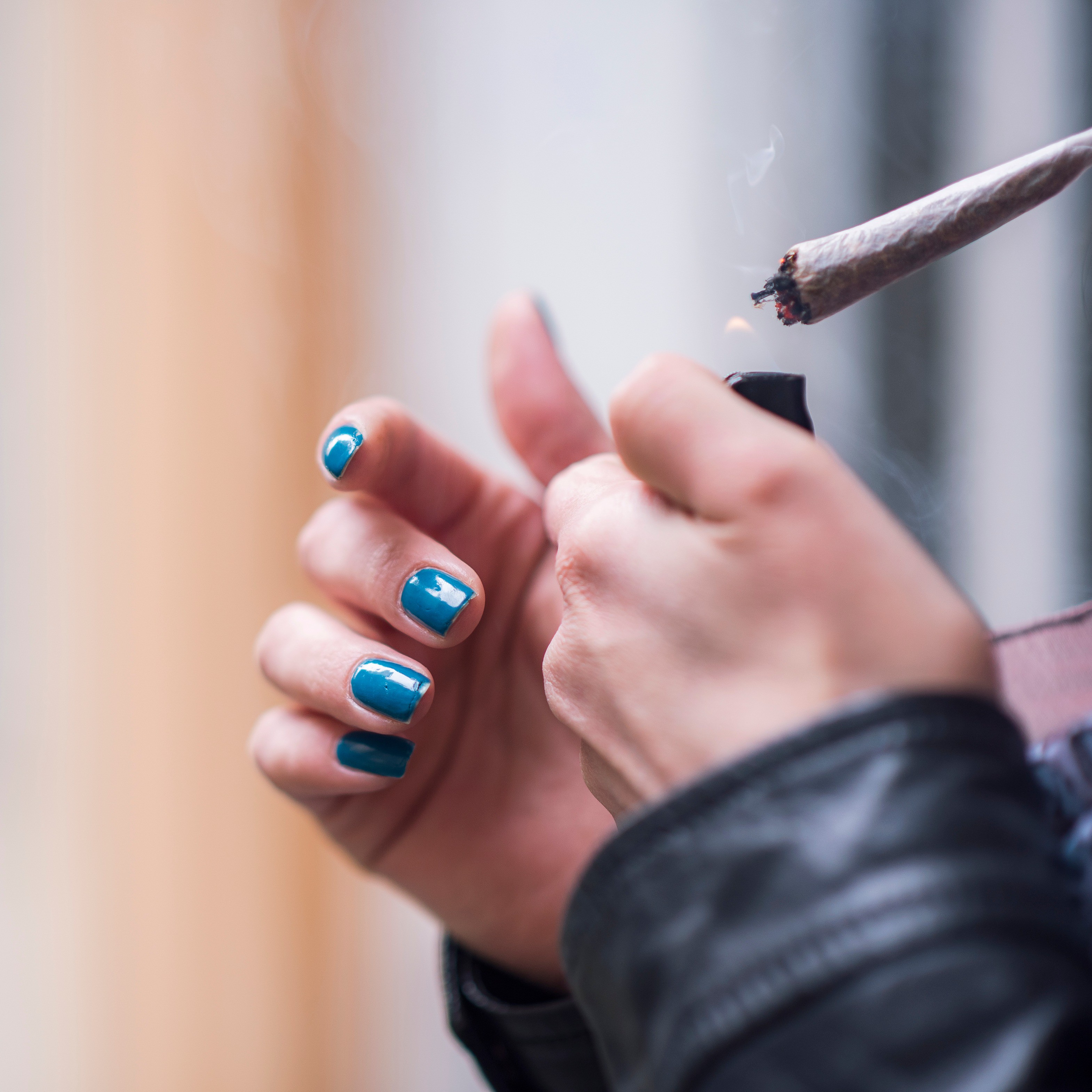 Cannabis Interview Fact Bild Nahaufnahme Hände: Eine Person zündet sich einen Joint an.
