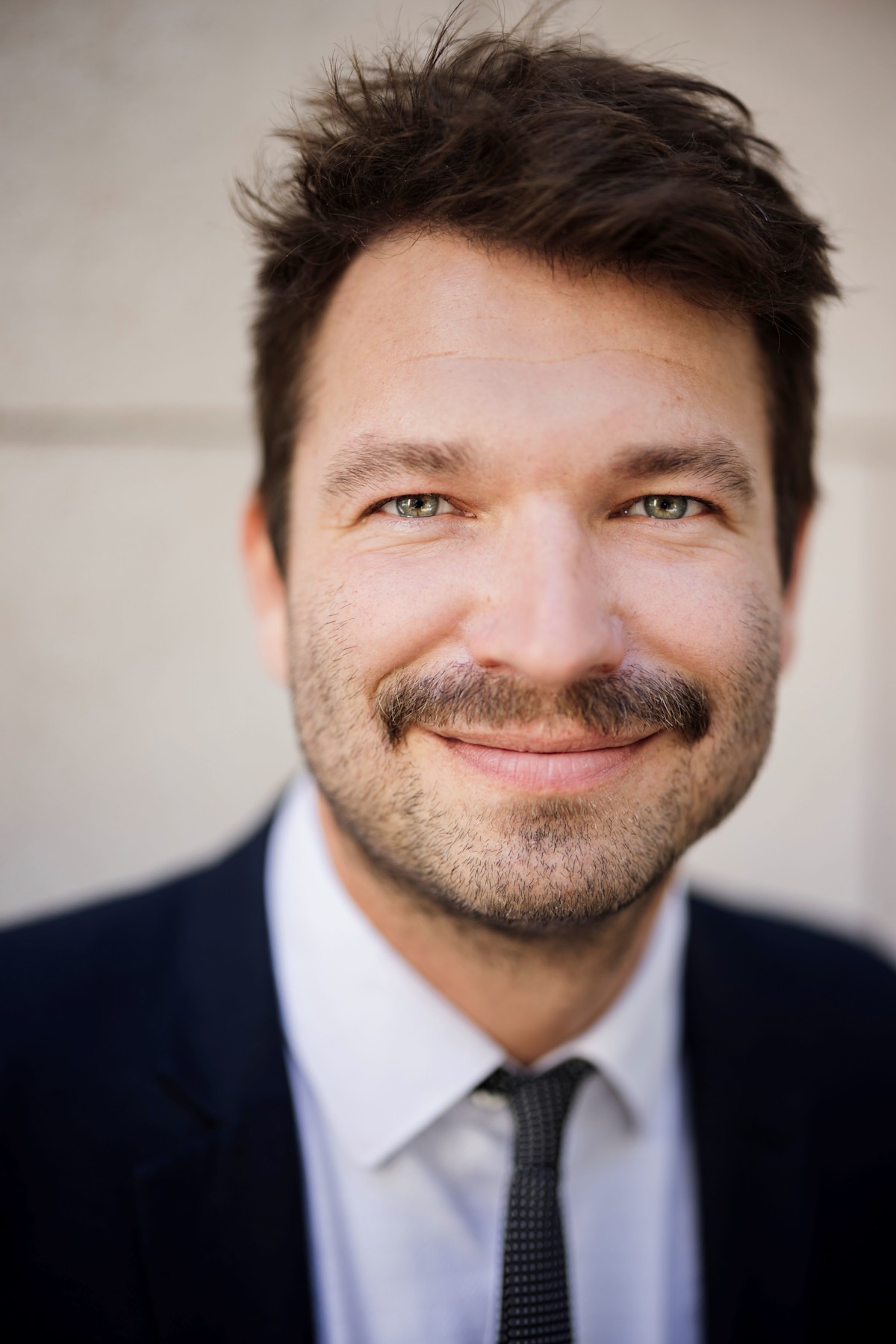 E-Bike oder Pedelec Robin Zalwert Ein Mann in Anzug und Krawatte lächelt in die Kamera. Es ist Robin Zalwert, Referent für nachhaltige Mobilität beim TÜV-Verband.
