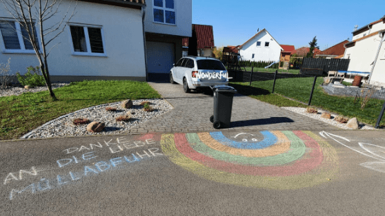 Auf einer Einfahrt vor einem Haus ist die Kreidezeichnung „Danke an die liebe Müllabfuhr” zu sehen. 